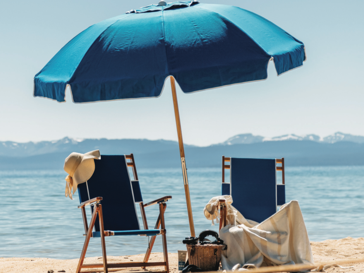 a couple of lawn chairs sitting on top of a sandy beach